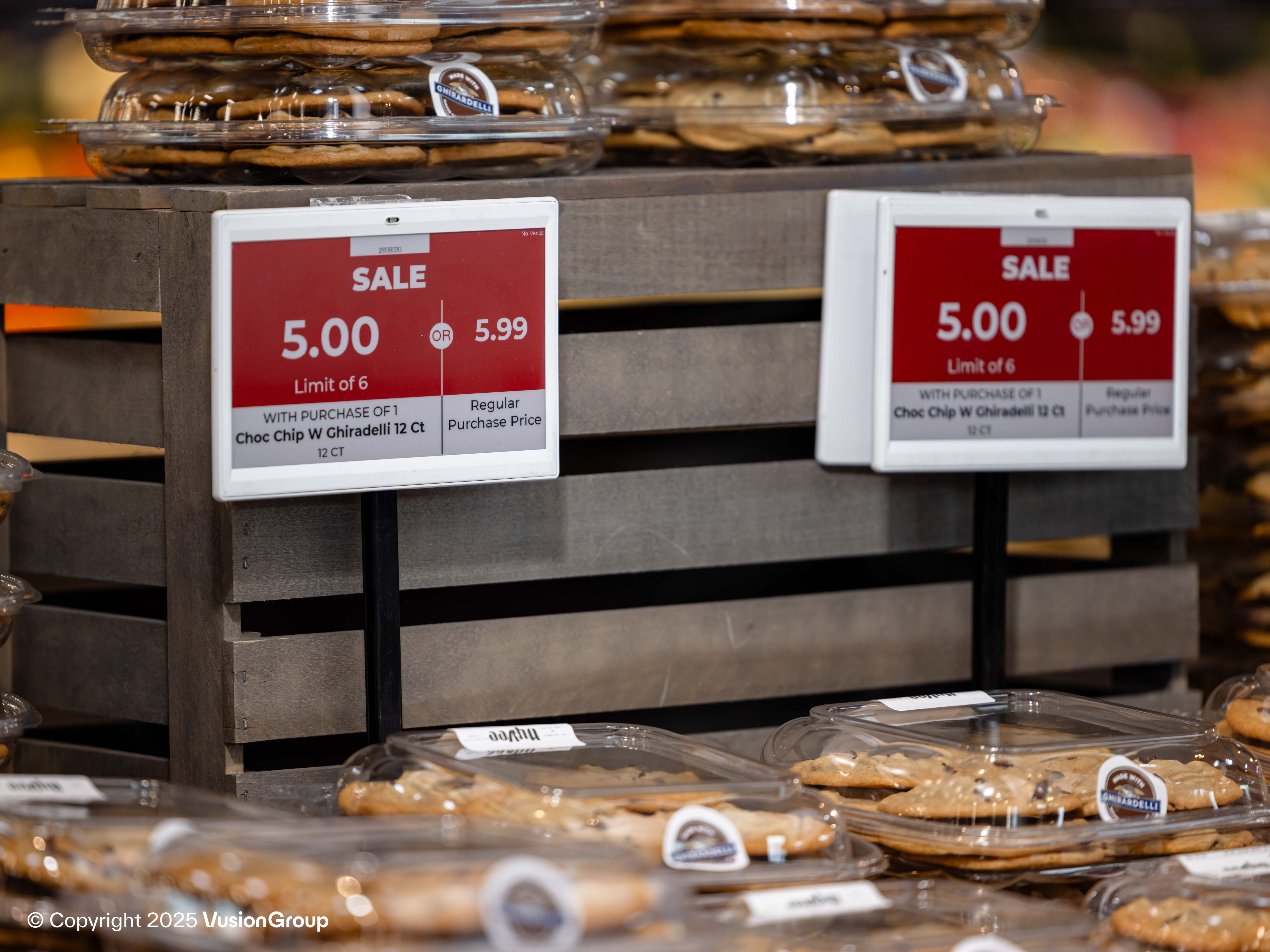 Bakery display table with red promo electronic shelf labels showing sale pricing, automated by DUMAC ESL system.